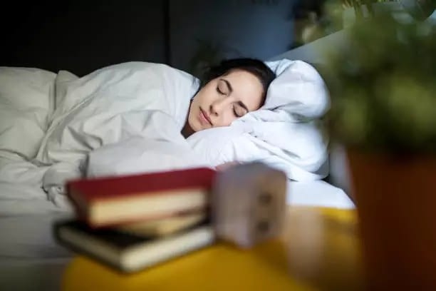 Young woman sleeping peacefully on her bed at home - need adequate sleep to gain immunity
